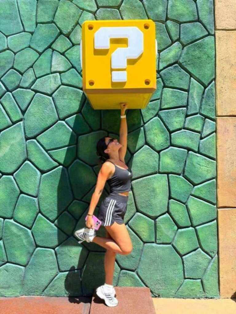 Antonela Roccuzzo posando junto a un bloque de preguntas en Epic Universe, Orlando