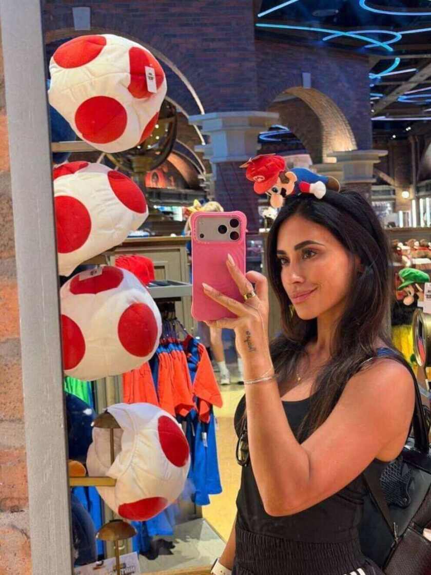 Antonela Roccuzzo tomando una selfie en una tienda de Epic Universe con gorros de Super Mario