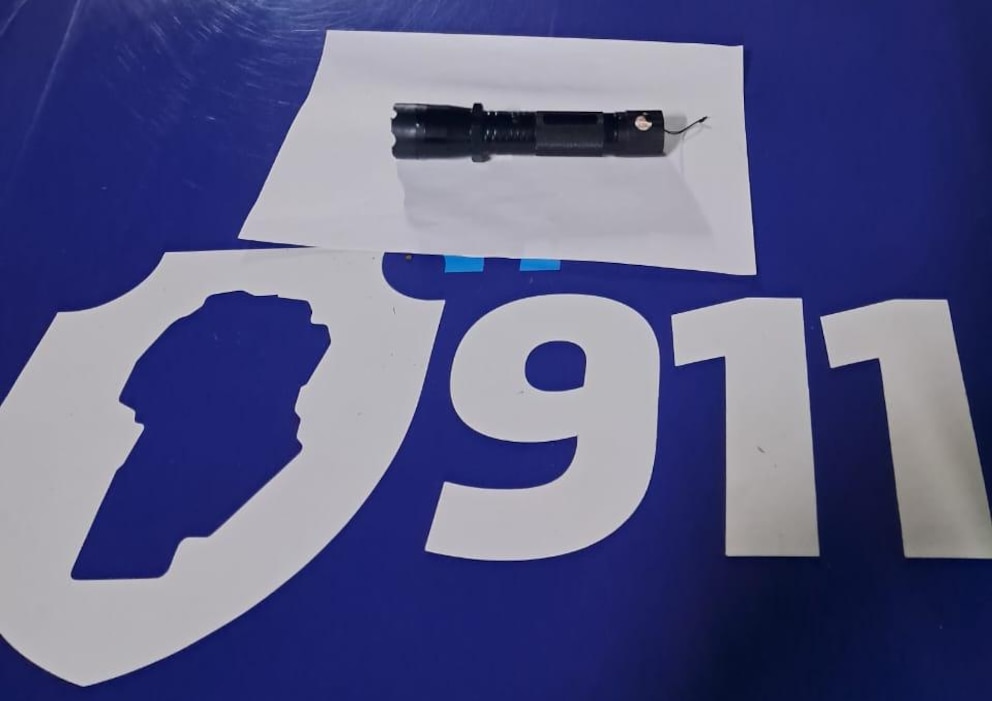 Dispositivo de descarga eléctrica sobre una mesa junto a un escudo policial en Córdoba