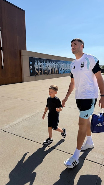 Lautaro Martínez caminando de la mano con un niño en Kansas City