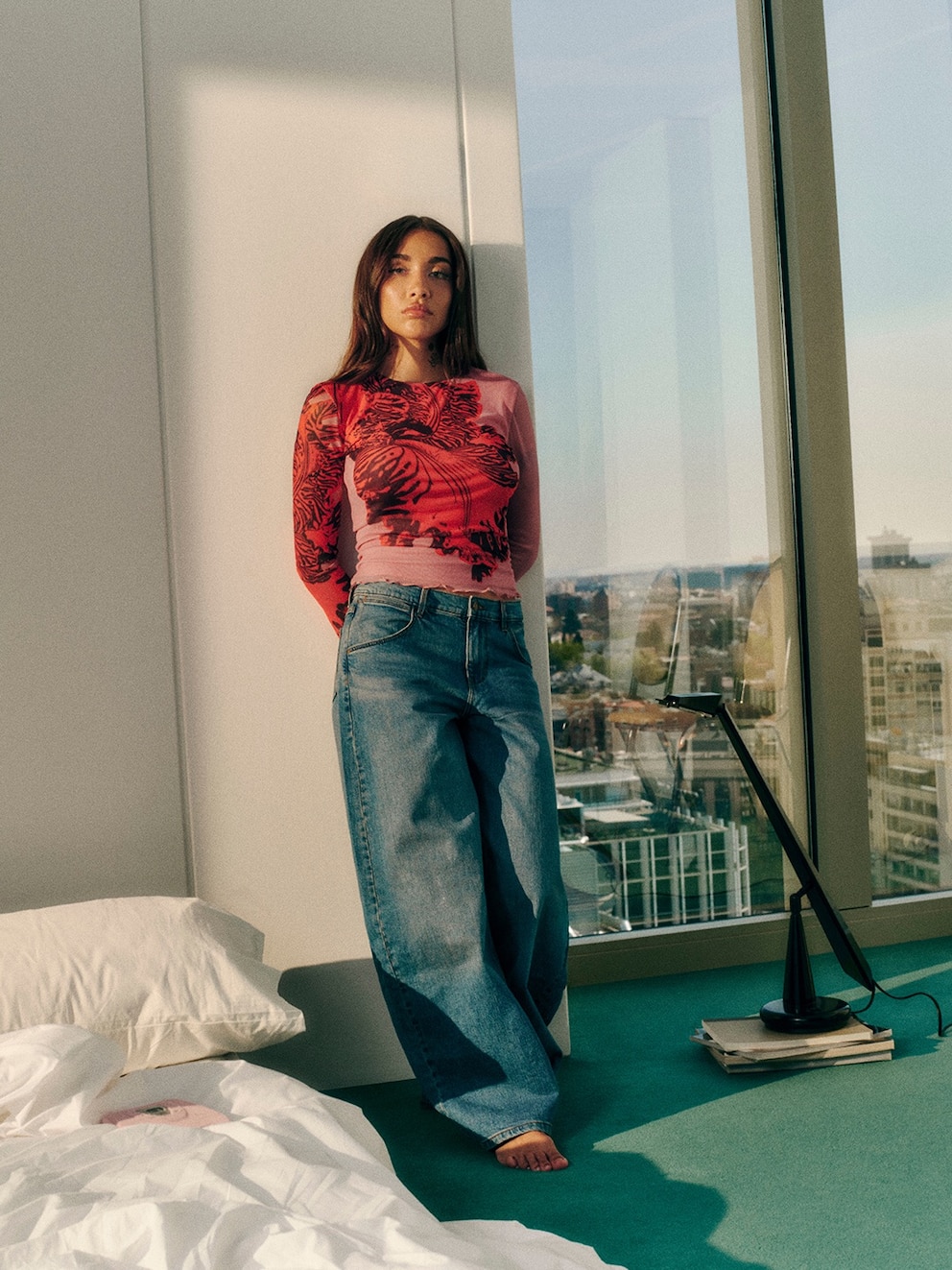 María Becerra posando como modelo en una habitación moderna con vista a la ciudad